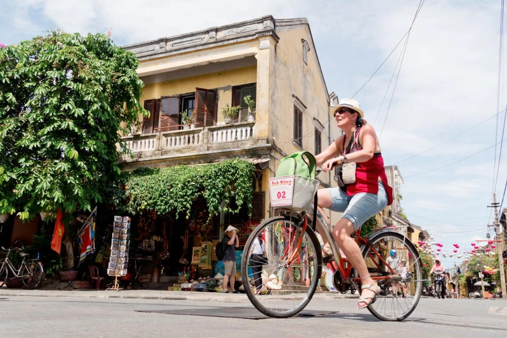 Hội An (Việt Nam) luôn biết cách làm say lòng lữ khách với những ngôi nhà màu vàng cũ kỹ nhuộm màu quá khứ. Nếu lần đầu hẹn hò với phố cổ dịu dàng, lãng mạn, bạn đừng bỏ lỡ trải nghiệm đạp xe để khám phá hết vẻ đẹp của nơi đây. Để thưởng thức vẻ đẹp vẹn nguyên của phố cổ, bạn nên thức dậy sớm vì đó là thời điểm không khí còn mát mẻ và ít người qua lại. Ảnh: Estherpoon/Shutterstock.