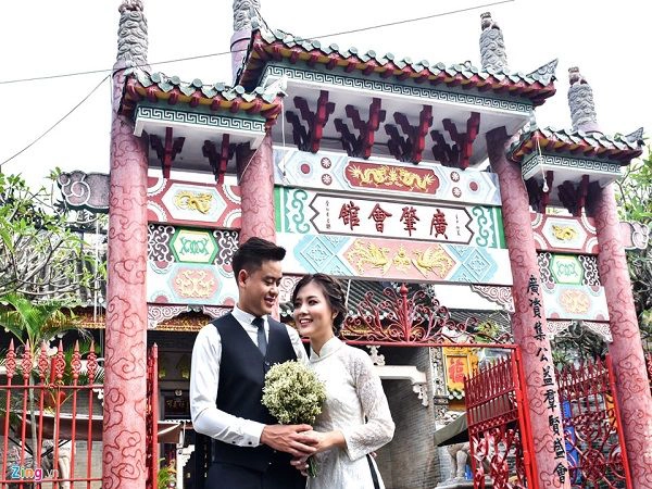 Cặp đôi Vũ Trường Giang và Phạm Thị Thu Trang (ngụ Hà Nội) chụp ảnh cưới trước cổng làm bằng chất liệu đá chạm khắc nhiều linh vật rồng, phương, kỳ lân..tinh xảo ở Hội quán Quảng Đông. Công trình này do cộng đồng bang hội thương nhân Quảng Đông xây dựng vào năm 1885 làm nơi sinh hoạt cộng đồng và tín ngưỡng riêng của người Quảng Đông ở phố cổ Hội An