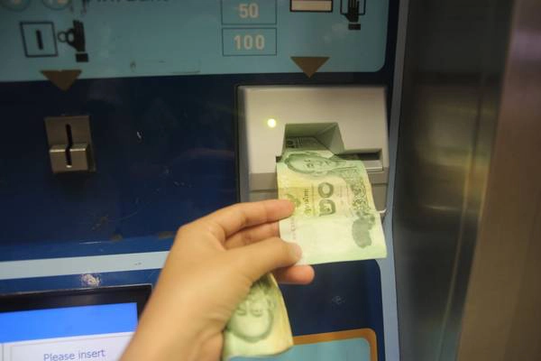 Nhét tiền vào khe thanh toán. Ảnh: San San Nhét tiền vào khe thanh toán. Ảnh: San San