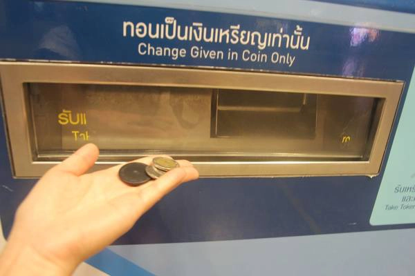 Nhận lại tiền thối và thẻ đi tàu điện ngầm ở khe phía dưới máy. Ảnh: San San Nhận lại tiền thối và thẻ đi tàu điện ngầm ở khe phía dưới máy. Ảnh: San San