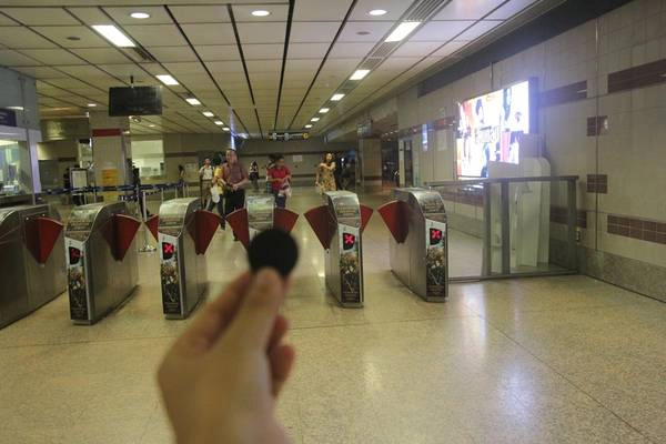 Sau khi mua vé xong cầm đồng xu bằng nhựa tiến đến khu vực kiểm soát vé. Ảnh: San San Sau khi mua vé xong cầm đồng xu bằng nhựa tiến đến khu vực kiểm soát vé. Ảnh: San San