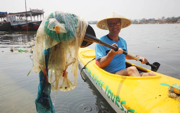 Thuyền được chèo gần bờ, nơi rác thải tấp vào. Sau đó du khách dùng vợt vớt.