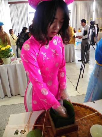 Nữ sinh viên Hàn Quốc này đến Việt Nam 6 tuần và đây là lần đầu tiên cô gói bánh chưng. Khó khăn của cô là công đoạn xếp lá tạo khuôn. goibanhchungtaimuine-ivivu-7