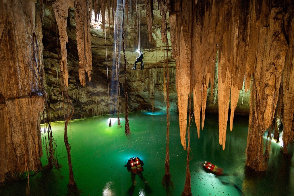 Trong vài thập kỷ khám phá những cenote, các nhà khảo cổ nhận ra người Maya coi nơi này là cánh cửa mở ra thế giới của Chaak, vị thần ban tặng những cơn mưa. Phía trong giếng, các bức tường tạo thành một mái vòm khổng lồ, những rễ cây xuyên qua đá để hút nước và nhũ đá ánh lên dưới tia nắng mặt trời. Ảnh: Pinterest.