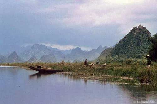 Làm ruộng giữa một bên là núi cao, một bên là sông dài.