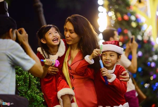 Chị Hồ Thảo (nhà ở quận Bình Thạnh) đưa hai bé Thảo Ly và Phương Trinh dạo chơi khu vực trung tâm đón Giáng sinh. Chị cho biết ngày cuối tuần ở nhà vì sợ người chen đông chật, nên chị cùng hai con dạo chơi vào tối thứ hai.