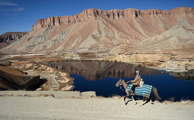 Một người đàn ông cưỡi ngựa nhìn ra hồ Band-e-Amir, nằm trong công viên quốc gia đầu tiên của Afghanistan tại tỉnh Bamiyan. Ngoài các hồ nước tuyệt đẹp, Bamiyan còn nổi tiếng với các bức tượng Phật khổng lồ chạm khắc vào núi đá gần 1.000 năm trước đây. Ảnh: Wakil Kohsar/AFP.