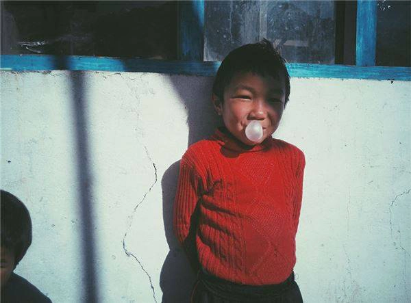 Một đứa trẻ đang chơi đùa bằng cách thổi kẹo cao su.