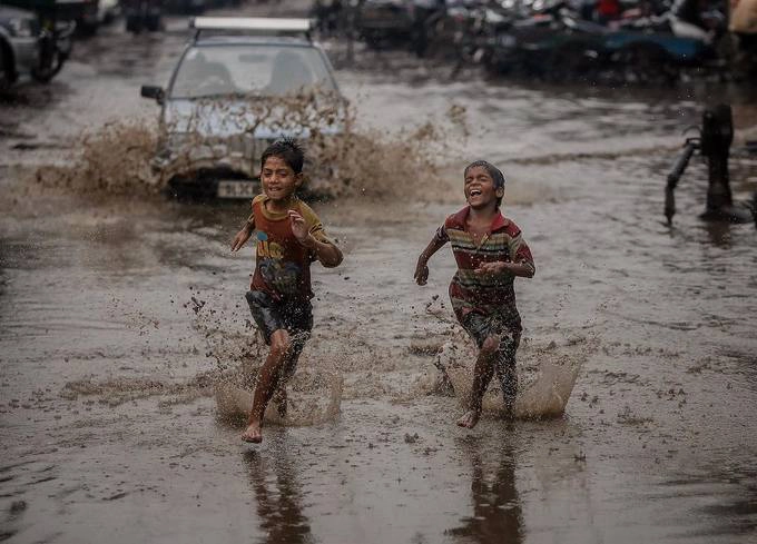 Những đứa trẻ chơi đùa trên đường phố ngập bùn lầy sau cơn mưa lớn. Những đứa trẻ chơi đùa trên đường phố ngập bùn lầy sau cơn mưa lớn.