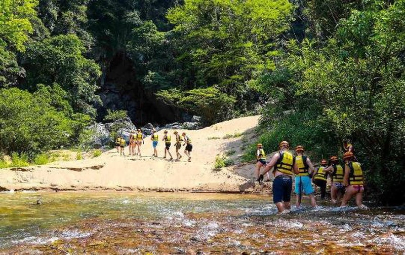 Du khách trải nghiệm qua bãi cát thơ mộng trước cửa hang Trạ Ang.