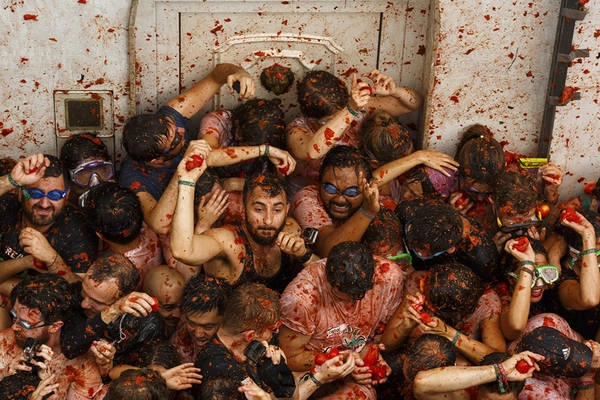 Lễ hội cà chua La Tomatina bắt nguồn từ sự kiện vào năm 1945, khi một nhóm thanh niên muốn giành vị trí trong cuộc diễu hành ở thị trấn Buñol, cách thành phố Valencia khoảng 40 km. Họ xô đẩy khiến nhiều người bị ngã, dẫn đến ẩu đả và lấy những quả cà chua để ném vào nhau. Ảnh: Pablo Blazquez Dominguez / Getty.