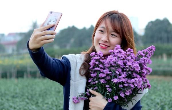 Không cần đến nhiếp ảnh gia, cô gái đôi mươi chụp ảnh selfie bằng điện thoại.