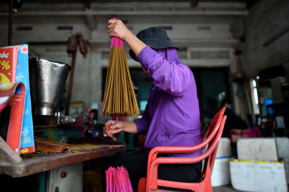 Việc se nhang trước đây được làm bằng tay, tròn hay méo phụ thuộc vào kinh nghiệm của người thợ. Nhưng từ ngày có máy phóng nhang, những nén nhang lúc nào cũng tròn đều đẹp mắt. Chân nhang sau khi được se bột sẽ được đem phơi khô trước khi đóng gói thành phẩm và bán đi khắp nơi - Ảnh: AFP