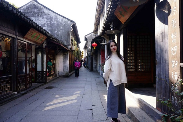 Một du khách nữ xinh đẹp làm dáng chụp ảnh trên con đường đá nhỏ ở cổ trấn Châu Trang. Ảnh: Nguyên Khôi