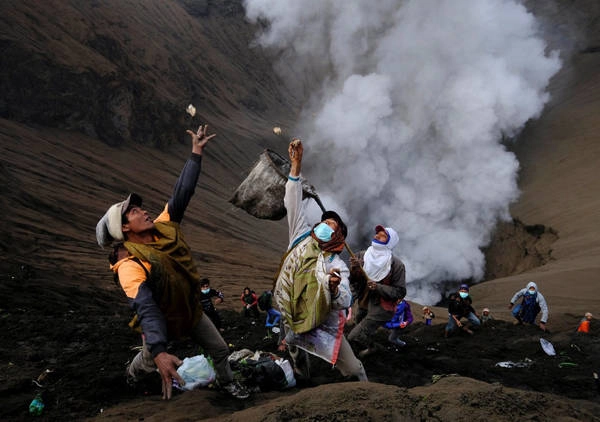  Nhiều người không sợ nguy hiểm, quay mặt về miệng núi lửa Bromo để bắt, chụp lấy lễ vật mà những tín đồ khác đã ném xuống.