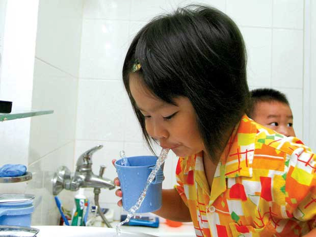 Cho bé súc miệng bằng nước muối pha loãng 0,9%