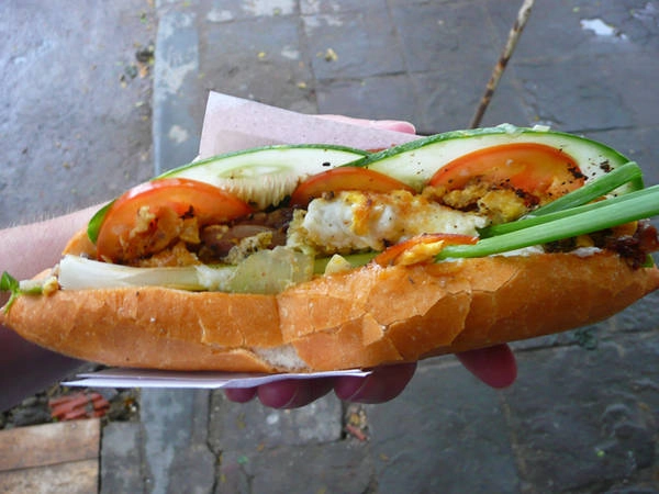 Bánh mì: Hãy xem nào, gồm có pa-tê, các loại thịt khác nhau, cà chua, dưa leo, tương ớt, hành, một quả trứng chiên và nhiều thứ khác nữa. Nó thật sự là một món ăn rất đặc biệt. Chỉ trong vòng 24h, tôi đã xơi 3 ổ bánh mì.