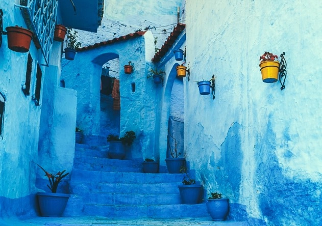 Tôi đến Chefchaouen vào những ngày cuối đông. Trong tiết trời lành lạnh, giữa thành phố tọa lạc trên ngọn đồi thoai thoải dốc, Morocco trong mắt tôi lúc này là một chấm nhỏ màu xanh da trời. Tôi bị cuốn hút bởi cách bài trí hàng hóa ngay ngắn dọc đường, quán cà phê nhỏ xinh góc phố. Những hình ảnh đó sẽ khiến bạn chăm chú nhìn ngắm, lần lữa giữa đi và dừng. Cả thị trấn cũ kỹ nhỏ xinh vẫn nhẹ nhàng diễn ra những cảnh sinh hoạt hàng ngày đầy sức sống nhưng đâu đó phảng phất một nét buồn rất khó gọi tên.