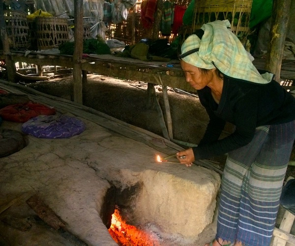 Buổi trưa trên đồi ở vùng đất Shan, Myanmar, người phụ nữ Myanmar đốt điếu thuốc lá do chính mình làm ra trên ngọn lửa đang sử dụng để hong khô lá cây thuốc lá - Ảnh: Bông Mai