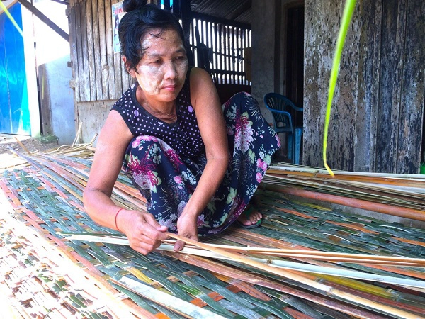 Bên bến sông, người phụ nữ Myanmar mãi miết đan vách bằng tre - Ảnh: Bông Mai