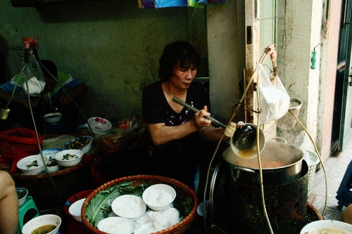 Bún ốc Hàng Chai  Ghánh bún ốc ba thế hệ của cô Thêm là địa chỉ ẩm thực nổi tiếng khu phố cổ. Chuyện xếp hàng 15-20 phút để đến lượt ăn bát bún ốc rất bình thường. Điều đặc trưng của tô bún Hàng Chai là chỉ gồm có bún, ốc và vài gia vị đi kèm như hành lá, cà chua. Nước dùng trong vắt, có phần chua hơn so với bún ốc khác nhưng vẫn rất thanh, đậm đà và vừa miệng. Ảnh: Phong Vinh.