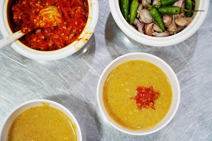 Nước chấm có màu vàng, sền sệt được nấu từ nước hầm xương và tương hột xay, gia giảm thêm một số loại gia vị cho vừa miệng. Khách gọi món tới đâu, đầu bếp sẽ múc nước chấm ra chén tới đó để đảm bảo độ nóng.