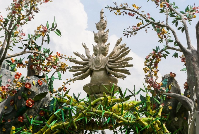 Trên đỉnh cổng chùa bài trí tượng Bồ tát nghìn tay ngồi trên đài sen, bao quanh là những nhành hoa mai, sala.