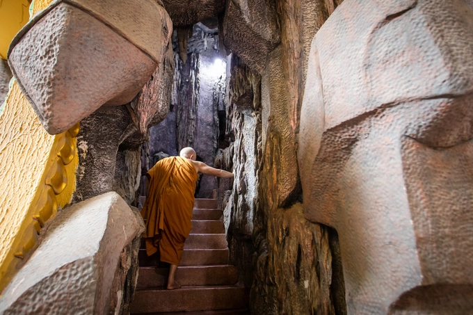 Lối lên chánh điện là dãy bậc thang với hang động đá hai bên. "Người ta thường nói 'năm non bảy núi', ở chùa đây cũng vậy, bên phải là núi Ngũ Hành (Đà Nẵng), bên trái là Thất Sơn ở miền Tây, cũng là biểu trưng cho bảy sắc thái tình cảm của con người (hỉ, nộ, ái, ố, ai, lạc và dục). Ai làm chủ được bản thân, người đó là thánh nhân", sư trụ trì giải thích thêm.