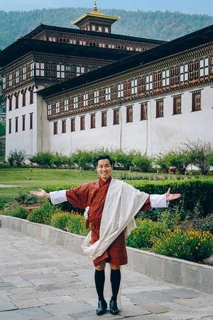 Anh cũng trải nghiệm cảm giác thú vị khi mặc Gho - quốc phục dành cho nam giới ở Bhutan khi đến thăm Tashichho Dzong được xây dựng năm 1641. Đây là một pháo đài vừa là cung điện, vừa là thủ phủ hành chính và tâm điểm của hoạt động tôn giáo. Bộ quốc phục gồm chiếc áo khoác rộng tay, dài đến gối, buộc thắt ngang hông, bên trong mặc quần short, chân mang giày vớ cao đến gối, có thêm khăn choàng.