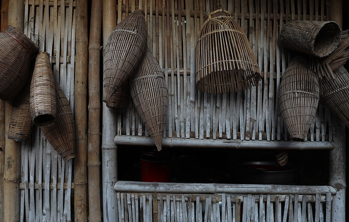 Những công cụ đánh bắt cá thô sơ trên bức tường (liếp) tre cạnh nhà.
