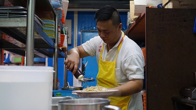 Đầu bếp đang chế biến các món ăn trong gian bếp chất đầy dụng cụ. Nhà hàng có 2 tầng, khách muốn ngồi ở phòng có điều hoà sẽ phải lên trên. Gian bếp ở phía dưới. Đầu bếp đang chế biến các món ăn trong gian bếp chất đầy dụng cụ. Nhà hàng có 2 tầng, khách muốn ngồi ở phòng có điều hoà sẽ phải lên trên. Gian bếp ở phía dưới.