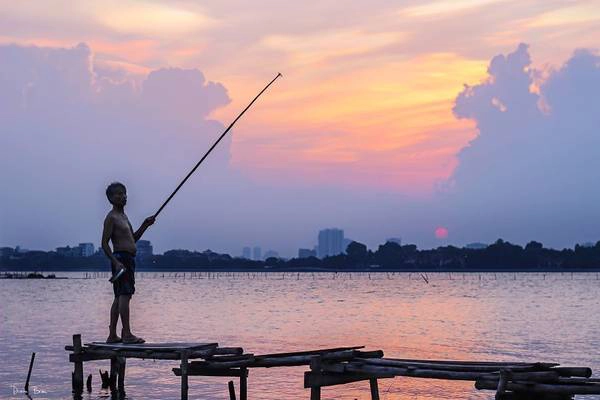 Một người đàn ông đang buông cần trên Hồ Tây. Một người đàn ông đang buông cần trên Hồ Tây.