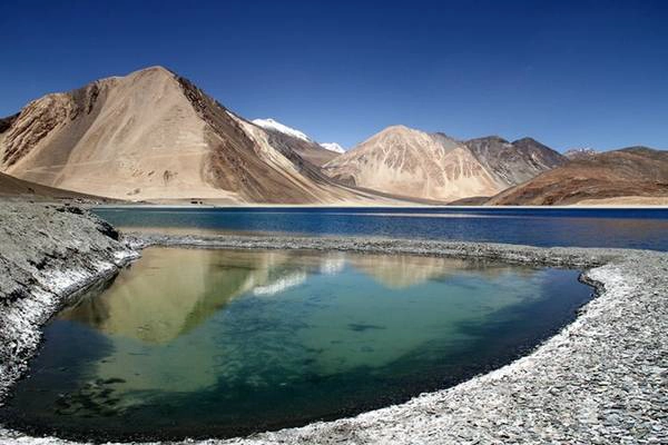 Tên gọi của hồ Pangong Tso mang ý nghĩa là hồ dài, hẹp và đẹp mê hoặc. Hồ nằm ở biên giới giữa Ấn Độ và Tây Tạng, mặt hồ trong vắt và phẳng lặng như một tấm gương khổng lồ, khiến du khách có thể nhìn tới tận đáy. Nhung-canh-dep-me-hon-nhung-it-du-khach-ivivu-10