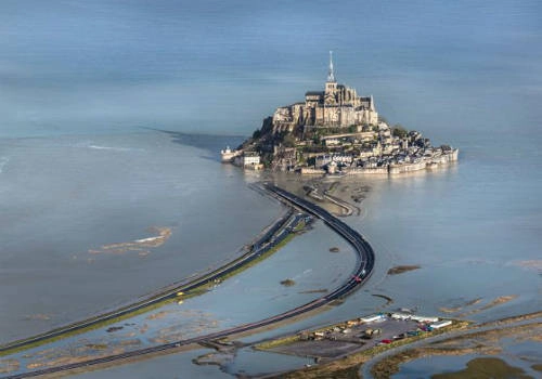 <strong>Đường giữa đất liền và đảo Mont Saint-Michel (Pháp): </strong> Để đến Mont Saint-Michel, du khách phải đi qua một con đường dài khoảng một km. Ngày trước, khi thủy triều lên, nơi đây trông cổ kính và huy hoàng như một pháo đài cô độc giữa biển khơi. Ngày nay, con đường xi măng dành cho cả ô tô và người đi bộ đã thay thế đường đất và cát xưa kia. Tuy nhiên với 15 m chênh lệch lúc thủy triều lên và xuống, nước vẫn tràn lên đường đi, biến Mont Saint-Michel thành một hòn đảo cổ tích giữa đại dương. Ảnh: lefigaro. <strong>Đường giữa đất liền và đảo Mont Saint-Michel (Pháp): </strong> Để đến Mont Saint-Michel, du khách phải đi qua một con đường dài khoảng một km. Ngày trước, khi thủy triều lên, nơi đây trông cổ kính và huy hoàng như một pháo đài cô độc giữa biển khơi. Ngày nay, con đường xi măng dành cho cả ô tô và người đi bộ đã thay thế đường đất và cát xưa kia. Tuy nhiên với 15 m chênh lệch lúc thủy triều lên và xuống, nước vẫn tràn lên đường đi, biến Mont Saint-Michel thành một hòn đảo cổ tích giữa đại dương. Ảnh: lefigaro.
