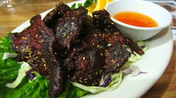 Sien Savanh (bò khô): Món bò khô của Lào rất hợp để ăn dọc đường hay ăn kèm khi uống bia. Thịt bò được ướp xì dầu, dầu hào, tỏi, ớt và đường cọ, rắc thêm hạt vừng rồi phơi khô dưới nắng. Các hàng ăn vỉa hè thường nướng qua để thịt bò có vị ám khói, dai dai, thơm ngon. Ảnh: Kqed. Sien Savanh (bò khô): Món bò khô của Lào rất hợp để ăn dọc đường hay ăn kèm khi uống bia. Thịt bò được ướp xì dầu, dầu hào, tỏi, ớt và đường cọ, rắc thêm hạt vừng rồi phơi khô dưới nắng. Các hàng ăn vỉa hè thường nướng qua để thịt bò có vị ám khói, dai dai, thơm ngon. Ảnh: Kqed.