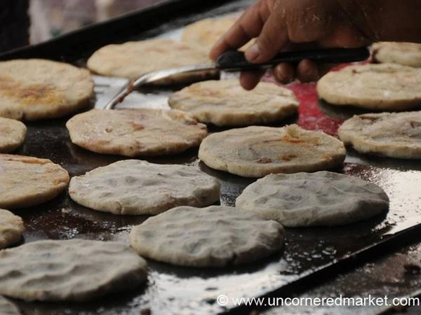 El Salvador: Pupusa gồm lớp vỏ bánh từ ngô, với nhân đậu đỏ, phô mai và chicharron (thịt ba chỉ rán), thêm dưa góp và ớt lên trên. Món này vừa rẻ, vừa no bụng và dễ tìm. Ảnh: Uncornered Market.