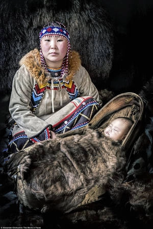 Một người mẹ dân tộc Evenki và con gái nhỏ của mình ở quận Neryungrinsky, Cộng hòa Sakha, Siberia. Người Evenki mặc quần áo phương Tây vào những tháng mùa hè, nhưng trong mùa đông lạnh, họ mặc trang phục truyền thống làm từ da báo và đeo trang sức đẹp bằng các loại hạt khác nhau tùy thuộc vào giới tính. Một người mẹ dân tộc Evenki và con gái nhỏ của mình ở quận Neryungrinsky, Cộng hòa Sakha, Siberia. Người Evenki mặc quần áo phương Tây vào những tháng mùa hè, nhưng trong mùa đông lạnh, họ mặc trang phục truyền thống làm từ da báo và đeo trang sức đẹp bằng các loại hạt khác nhau tùy thuộc vào giới tính.