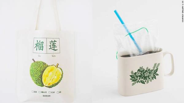 Bên trái là một chiếc túi tote có in biểu tượng quả sầu riêng và bên phải là cà phê kopi. Du khách có thể mua hai món này tại Gallery & Co. Bên trái là một chiếc túi tote có in biểu tượng quả sầu riêng và bên phải là cà phê kopi. Du khách có thể mua hai món này tại Gallery & Co.
