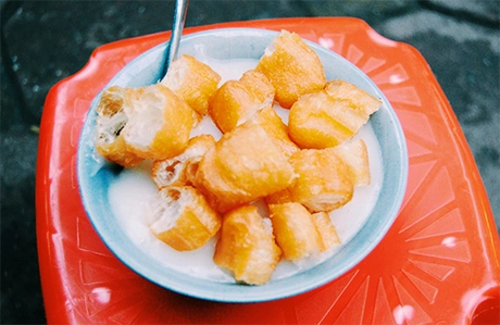 Cháo sườn, cháo trai Ngoài cổng các trường mầm non, tiểu học thường có một quán bán cháo sườn, cháo trai cho trẻ nhỏ trước giờ vào lớp. Không chỉ phục vụ các bé, món ăn đơn giản cũng thu hút cả các bậc phụ huynh tranh thủ lúc đợi con. Dần dà, cháo sườn, cháo trai trở thành ăn vặt phổ biến lúc xế chiều, nổi tiếng ngon và giá rẻ là hàng ở các khu tập thể Nghĩa Tân, Thành Công. Phần cháo nấu từ bột xay nhuyễn mềm mịn, ăn dễ vào. Thành phần thường có thêm sườn và trai tùy nhu cầu của khách. Nhiều quán dễ tính bán cả những suất chỉ có 5.000 đồng. Khách có thể gọi thêm quẩy, ruốc để món ăn thêm đậm đà. Ảnh: Nguyên Chi. Cháo sườn, cháo trai Ngoài cổng các trường mầm non, tiểu học thường có một quán bán cháo sườn, cháo trai cho trẻ nhỏ trước giờ vào lớp. Không chỉ phục vụ các bé, món ăn đơn giản cũng thu hút cả các bậc phụ huynh tranh thủ lúc đợi con. Dần dà, cháo sườn, cháo trai trở thành ăn vặt phổ biến lúc xế chiều, nổi tiếng ngon và giá rẻ là hàng ở các khu tập thể Nghĩa Tân, Thành Công. Phần cháo nấu từ bột xay nhuyễn mềm mịn, ăn dễ vào. Thành phần thường có thêm sườn và trai tùy nhu cầu của khách. Nhiều quán dễ tính bán cả những suất chỉ có 5.000 đồng. Khách có thể gọi thêm quẩy, ruốc để món ăn thêm đậm đà. Ảnh: Nguyên Chi.