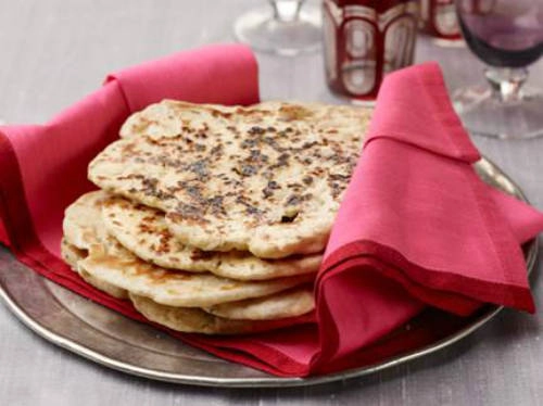 Bánh mỳ Naan Naan là bánh mỳ đặc trưng mọi vùng miền Ấn Độ, làm từ nguyên liệu cơ bản bột mỳ và men khô. Tuy nhiên cách chế biến khá cầu kỳ và phức tạp, đòi hỏi tay nghề cao trong cách nhào nặn bột, sau đó xếp quanh nồi để nướng chín. Bánh dùng kèm với nước sốt cà ri và pho mát, độ đậm đà của cà ri tùy theo sở thích người ăn. Ảnh: Food Network.