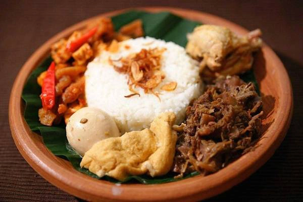 Gudeg: Gudeg là đặc sản của thành phố Yogyakarta. Mít được hầm hàng tiếng liền cùng nước dừa, đường cọ cho tới khi mềm. Món ăn ngọt ngào này được thêm một số gia vị, trong đó có lá tếch để tạo màu nâu hấp dẫn. Gudeg được ăn cùng cơm, trứng luộc, gà và da bò chiên giòn. Ảnh: Wonderfuljogja.