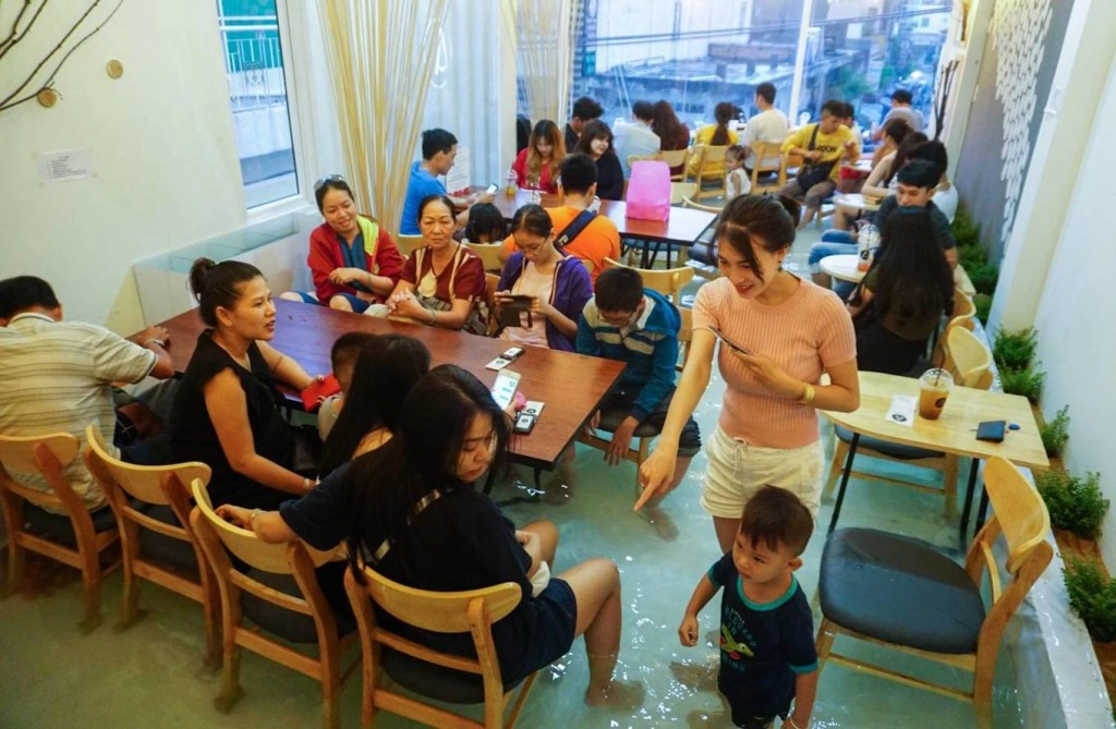Amix Coffee Nằm ngay mặt tiền đường Phạm Văn Hai, quận Tân Bình, quán cà phê được thiết kế có nhiều tầng. Vào quán, khách sẽ gọi món trước ở tầng trệt rồi thoải mái lựa chọn không gian ngồi ở hai tầng trên. Điều khiến thực khách thích thú và tạo "cơn sốt" khi quán vừa mới hoạt động hồi tháng 6 là không gian bể cá cho khách lội vào bên trong. Mô hình do Ngô Được Hòa (22 tuổi) nghĩ ra. Theo đó, bể nước rộng 25 m2 và nuôi thả nhiều loại cá. Ảnh: Quỳnh Trần. Amix Coffee Nằm ngay mặt tiền đường Phạm Văn Hai, quận Tân Bình, quán cà phê được thiết kế có nhiều tầng. Vào quán, khách sẽ gọi món trước ở tầng trệt rồi thoải mái lựa chọn không gian ngồi ở hai tầng trên. Điều khiến thực khách thích thú và tạo "cơn sốt" khi quán vừa mới hoạt động hồi tháng 6 là không gian bể cá cho khách lội vào bên trong. Mô hình do Ngô Được Hòa (22 tuổi) nghĩ ra. Theo đó, bể nước rộng 25 m2 và nuôi thả nhiều loại cá. Ảnh: Quỳnh Trần.