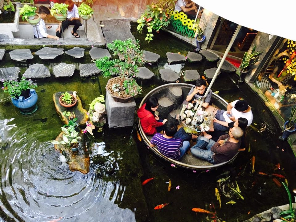 Oasis Coffee Không gian ngoài trời có lẽ là khu hút khách nhất của quán cà phê trên đường Lê Lợi, quận Gò Vấp. Cây cối được bố trí khắp nơi tạo cảm giác thoải mái, gần gũi thiên nhiên. Phần không gian này còn được thiết kế thêm bàn ngồi dưới lòng hồ cá. Khách ngồi uống cà phê sẽ có cảm giác như đang "bơi cùng bầy cá". Ảnh: Đỗ Hoàn Tuấn. Oasis Coffee Không gian ngoài trời có lẽ là khu hút khách nhất của quán cà phê trên đường Lê Lợi, quận Gò Vấp. Cây cối được bố trí khắp nơi tạo cảm giác thoải mái, gần gũi thiên nhiên. Phần không gian này còn được thiết kế thêm bàn ngồi dưới lòng hồ cá. Khách ngồi uống cà phê sẽ có cảm giác như đang "bơi cùng bầy cá". Ảnh: Đỗ Hoàn Tuấn.