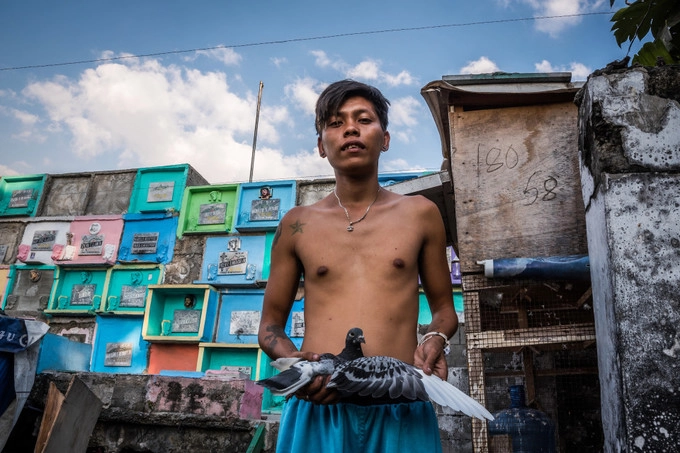 "Đó là nơi vợ chồng tôi ngủ khi trời mưa", Edwin Orcocoy, người đã sống ở nghĩa trang 19 năm, cho biết. Một người khác cho biết, lý do để anh sống ở đây là: "Tôi muốn được nhìn thấy mộ của con trai mình mỗi khi thức dậy". Trên ảnh là Kambal, anh đã sống ở đây 11 năm.