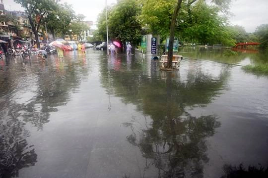 Cơn mưa kéo dài làm nước không thoát được nhanh, một đoạn vỉa hè Đinh Tiên Hoàng (đoạn gần quảng trường Đông Kinh Nghĩa Thục) rơi vào cảnh ngập lụt. 