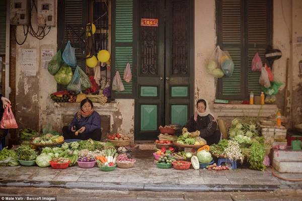 Đường phố có nhiều người bán đồ ăn. Hai người phụ nữ này bán hoa quả và rau củ.
