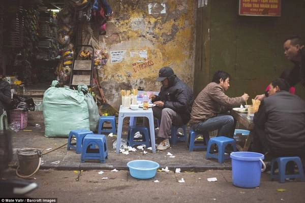 Đường phố nhộn nhịp với người dân địa phương ngồi ăn trên những chiếc ghế nhựa nhỏ, thấp. 
