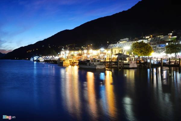 Vào ban đêm, trung tâm Queenstown sáng rực bởi những ngọn đèn hắt ra từ các ngôi nhà dưới chân núi. Trong ảnh, khung cảnh nơi này lúc 20h khi mặt trời vừa lặn, yên tĩnh và lộng gió.