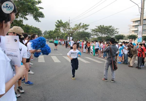 Một em nhỏ đang chạy về đích trong tiếng cổ vũ nhiệt tình của mọi người. 