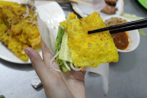 Bánh được dọn ra đĩa nóng hổi, cắt đôi miếng bánh cho dễ cuốn, bên cạnh là đĩa rau sống, đu đủ chua và dưa leo cuốn kèm bánh tráng mỏng. Bánh được dọn ra đĩa nóng hổi, cắt đôi miếng bánh cho dễ cuốn, bên cạnh là đĩa rau sống, đu đủ chua và dưa leo cuốn kèm bánh tráng mỏng.